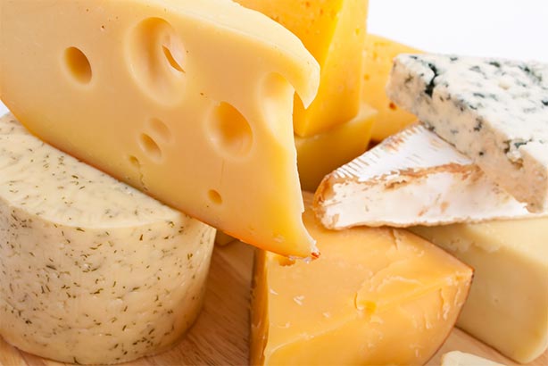 Miscellaneous cheese types on a wooden cutting board